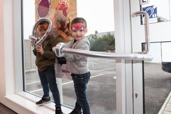 Boys with their faces painted and a chrome balloon silver sword.