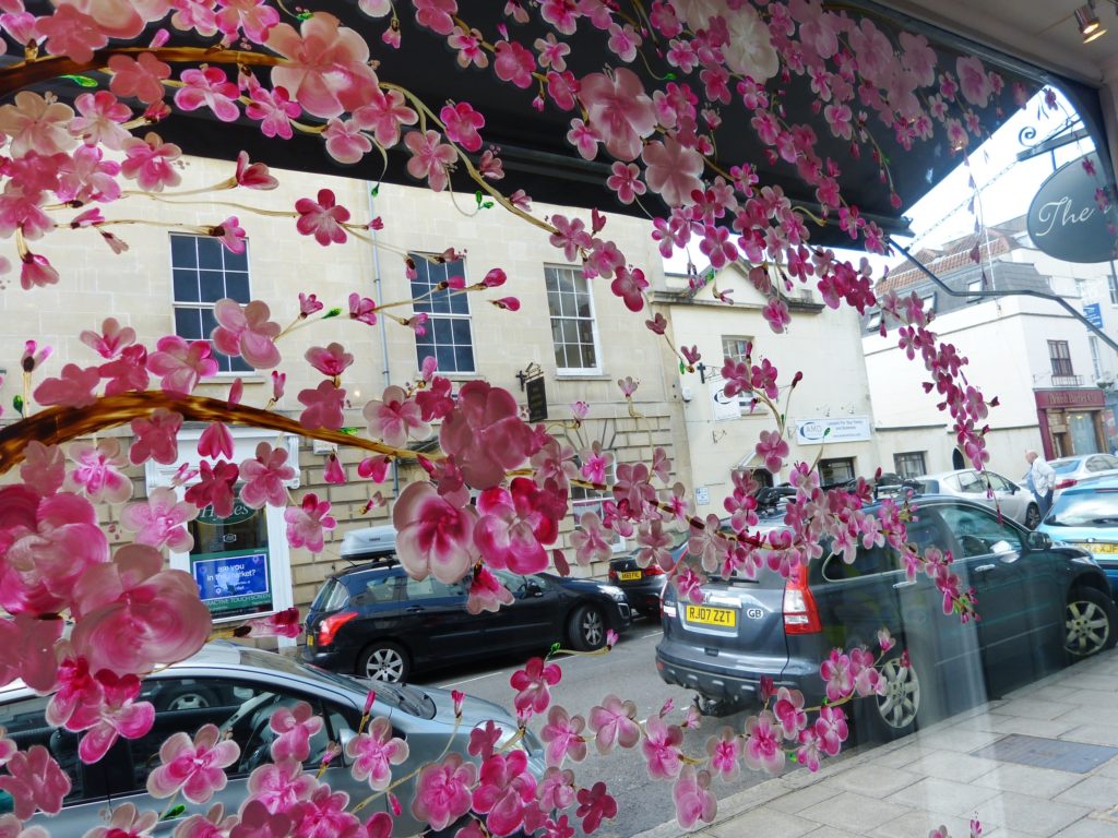 Inside shop window display cherry blossom painting.