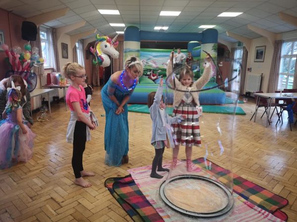 Unicorn theme party with bouncy castle and bubble entertainers.