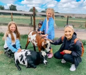Kids petting goats at a party in Bristol.